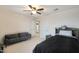 Spacious bedroom with a ceiling fan, sofa, and access to the bathroom at 17706 W Villa Chula Ln, Surprise, AZ 85387