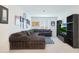 A spacious bonus room with a sectional sofa, stylish decor, and a TV setup, perfect for entertainment and relaxation at 17706 W Villa Chula Ln, Surprise, AZ 85387