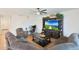 Spacious living room featuring a large sectional, entertainment center, and a ceiling fan at 17706 W Villa Chula Ln, Surprise, AZ 85387