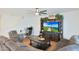 Inviting living room with comfortable seating, a large TV, and a dedicated workspace at 17706 W Villa Chula Ln, Surprise, AZ 85387