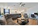 Open-concept living room with a large sectional sofa, kitchen view, and hardwood floors at 17706 W Villa Chula Ln, Surprise, AZ 85387