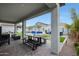 Covered patio offers a relaxing view of the pool, spa, and beautifully landscaped backyard at 17706 W Villa Chula Ln, Surprise, AZ 85387