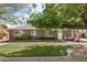 Charming single-story home featuring a well-manicured lawn and mature trees, enhancing its curb appeal at 1815 N 74Th St, Scottsdale, AZ 85257