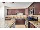 Well-equipped kitchen featuring dark wood cabinetry, granite countertops, and stainless steel appliances at 1815 N 74Th St, Scottsdale, AZ 85257