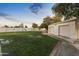 Large grassy backyard with playset, mature trees, and detached garage at 1848 E Mallory St, Mesa, AZ 85203