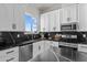 Modern kitchen with white cabinets, black countertops, and stainless steel appliances at 28813 N 201St Ave, Wittmann, AZ 85361