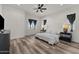 Spacious main bedroom with wood-look floors and ceiling fan at 28813 N 201St Ave, Wittmann, AZ 85361