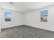 Bright bedroom with grey carpet and two windows at 40055 W Venture Rd, Maricopa, AZ 85138