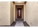 Front entry with a dark wood door and neutral-colored walls at 42493 W Candyland Pl, Maricopa, AZ 85138