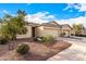 Tan two-story house with two car garage and desert landscaping at 42493 W Candyland Pl, Maricopa, AZ 85138