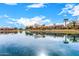 Tranquil lake view with reflections of homes at 42493 W Candyland Pl, Maricopa, AZ 85138