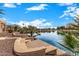 Backyard patio overlooking a lake with manicured landscaping at 42493 W Candyland Pl, Maricopa, AZ 85138