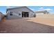 A spacious backyard with ample room for outdoor living, featuring a covered patio and neutral toned home exterior at 46941 W Old Timer Rd, Maricopa, AZ 85139