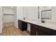 A bright bathroom with a double sink vanity, wood-look floors, and a walk-in closet at 46941 W Old Timer Rd, Maricopa, AZ 85139