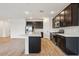 Modern kitchen featuring dark cabinets, stainless steel appliances, an island and tiled flooring at 46941 W Old Timer Rd, Maricopa, AZ 85139