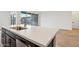 Close-up of a kitchen island with a white countertop, stainless steel dishwasher, and modern fixtures at 46941 W Old Timer Rd, Maricopa, AZ 85139