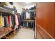 A neatly organized walk-in closet has shelves, hanging rods, and shoe storage at 4909 N Woodmere Fairway -- # 2003, Scottsdale, AZ 85251
