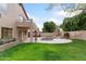 Extensive backyard with well-manicured lawn, pool with waterfall, and lush landscaping at 5102 E Charleston Ave, Scottsdale, AZ 85254