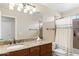 Bright bathroom with granite countertop, wood cabinets, and shower with neutral walls at 5102 E Charleston Ave, Scottsdale, AZ 85254