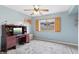 Spacious bedroom with a desk, ceiling fan, light-colored walls, and a decorative carpet at 5102 E Charleston Ave, Scottsdale, AZ 85254