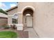 Inviting front entryway with an arched doorway, decorative door, and desert landscaping at 5102 E Charleston Ave, Scottsdale, AZ 85254