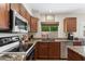 Well-equipped kitchen boasts wood cabinetry, granite countertops, stainless appliances and window views to the backyard at 5102 E Charleston Ave, Scottsdale, AZ 85254
