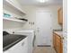 Laundry room with washer, dryer, sink, storage cabinets, and a white door at 5102 E Charleston Ave, Scottsdale, AZ 85254