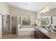 Bright bathroom features a shower, soaking tub, granite vanity and a large window offering serene backyard views at 5102 E Charleston Ave, Scottsdale, AZ 85254