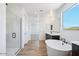 Bright bathroom features a soaking tub, dark cabinets, and a shower with glass door at 7662 W Rowel Rd, Peoria, AZ 85383