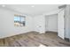Bright bedroom featuring wood-look floors, white walls, and window view at 7662 W Rowel Rd, Peoria, AZ 85383