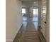 Hallway view leads to open concept living area with wood look floors and white walls at 7662 W Rowel Rd, Peoria, AZ 85383