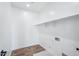 Bright laundry room featuring wood-look tile flooring and functional shelving at 7662 W Rowel Rd, Peoria, AZ 85383