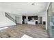 Spacious living room with wood-look floors, recessed lighting, and staircase near the kitchen and sliding glass doors at 7662 W Rowel Rd, Peoria, AZ 85383