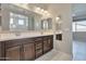 Double vanity bathroom with dark brown cabinets and a large mirror at 8026 W Wood Ln, Phoenix, AZ 85043