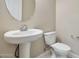 Simple yet elegant pedestal sink and toilet in this half-bathroom at 8026 W Wood Ln, Phoenix, AZ 85043