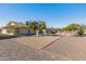Backyard view of home with fruit trees and gravel at 9814 W Cedar Dr, Sun City, AZ 85351