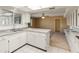 Spacious kitchen featuring white cabinets and a breakfast bar at 9814 W Cedar Dr, Sun City, AZ 85351