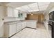 Bright kitchen with white cabinets and tiled floors at 9814 W Cedar Dr, Sun City, AZ 85351