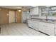 Kitchen with white cabinets, tile floor, and access to backyard at 9814 W Cedar Dr, Sun City, AZ 85351