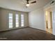 Bright bedroom with carpet, three windows and door to bathroom at 10976 W Coggins Dr, Sun City, AZ 85351
