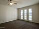 Spacious bedroom with wall-to-wall carpet and three large windows at 10976 W Coggins Dr, Sun City, AZ 85351