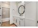 Clean bathroom with white vanity, round mirror and gray tile at 12058 N Loma Linda St, Surprise, AZ 85388
