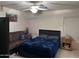 Cozy bedroom with a double bed, couch, and ceiling fan at 12701 W Paradise Dr, El Mirage, AZ 85335