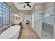 Bathroom featuring a glass shower, soaking tub, dual sinks, and access to the main bedroom at 12953 W Figueroa Dr, Sun City West, AZ 85375