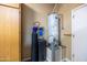 Utility room featuring a hot water tank, water filtration system, and custom cabinets at 12953 W Figueroa Dr, Sun City West, AZ 85375