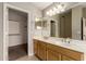 Bathroom with a double vanity, wood cabinets and a large mirror at 1360 E Century Ave, Gilbert, AZ 85296