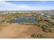 Aerial view of community featuring a lake and surrounding desert landscape at 14821 E Chandler Heights Rd, Chandler, AZ 85249