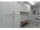 Bright laundry room with ample cabinetry and a convenient bench at 14821 E Chandler Heights Rd, Chandler, AZ 85249