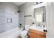 Modern bathroom with a soaking tub, wood vanity, and gray tile at 14866 W Windsor Ave, Goodyear, AZ 85395