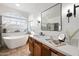 Elegant bathroom featuring a white soaking tub and a double vanity at 14866 W Windsor Ave, Goodyear, AZ 85395